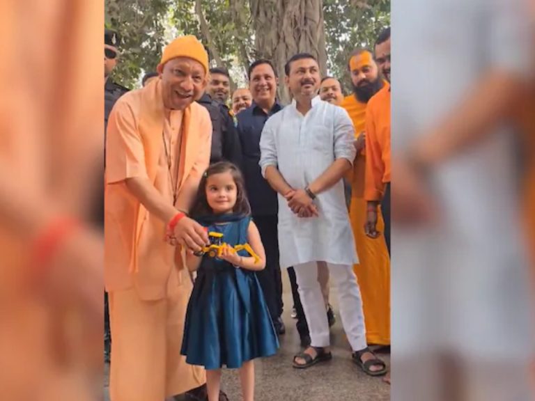 little girl yashaswini gift mini bulldozer toy to cm yogi in gorakhnath Mandir
